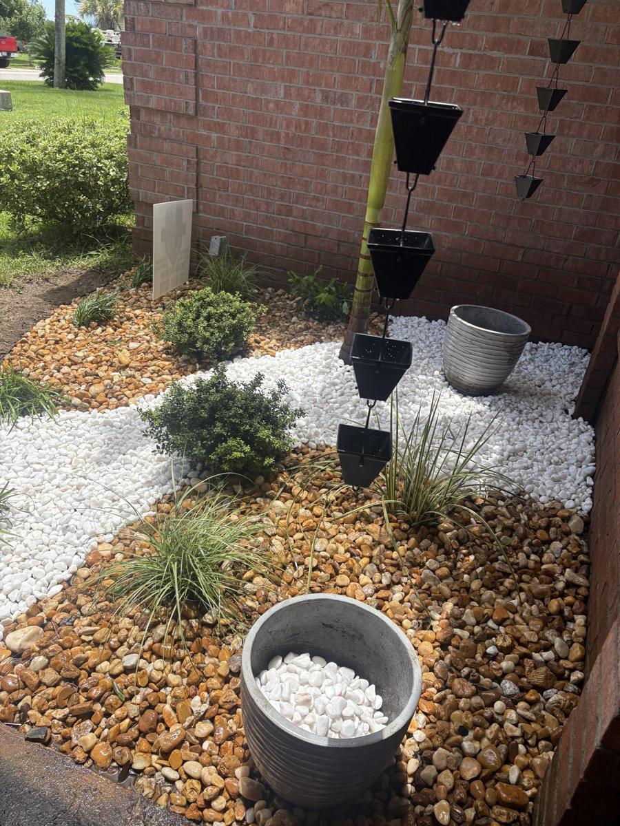 River rock and white stone bed under a rain chain