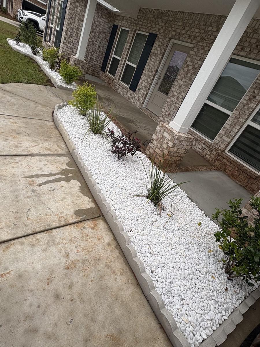 White rock bed along a concrete porch