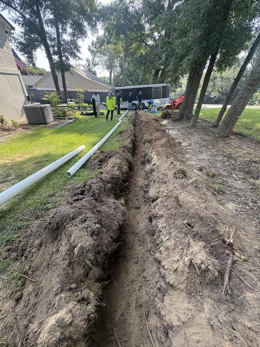 Long drain trench dug across a wooded property