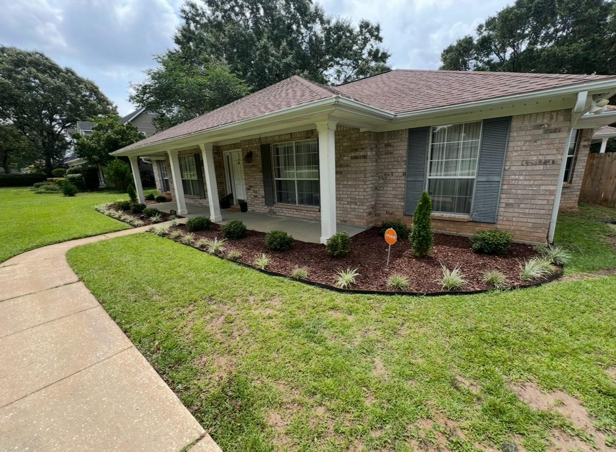 Freshly cut lawn and edged walk in front of a brick home