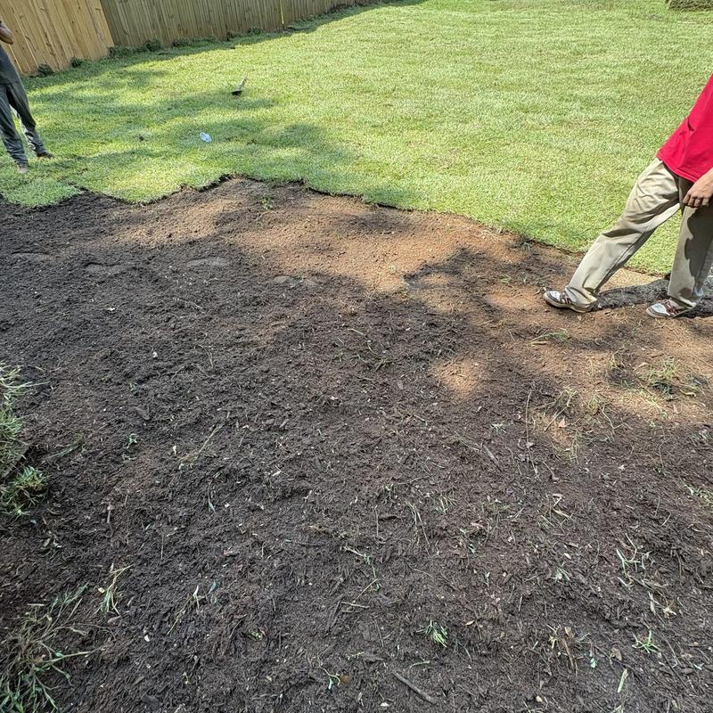 New sod going down along a backyard fence